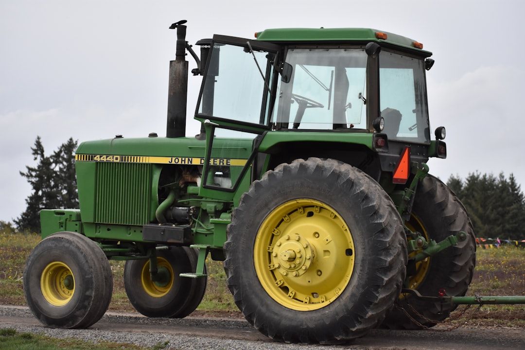 En grön och gul John Deere 4440 traktor parkerad utomhus.