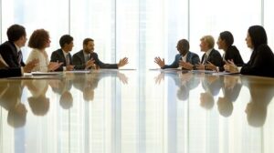 Delägare diskuterar vid ett långt konferensbord i ett ljust mötesrum